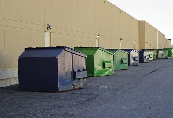 a construction worker empties a wheelbarrow of waste into the dumpster in Hope, MI